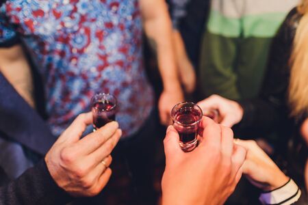 Bartender pouring strong alcoholic drink into small glasses on bar, shots.の写真素材