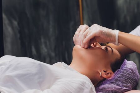 cosmetologist makes a buccal massage of the patients facial muscles.の写真素材