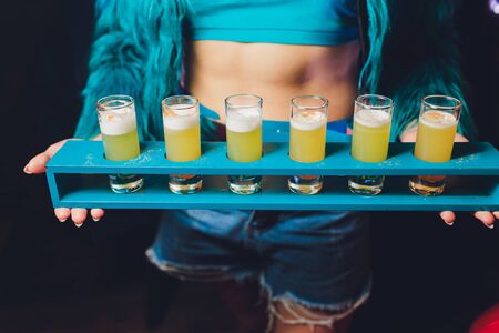 Waiter serving shots on a wooden trayの写真素材