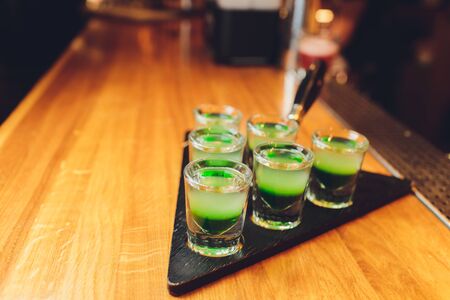 Barman make alcoholic shots with rum and liquor.