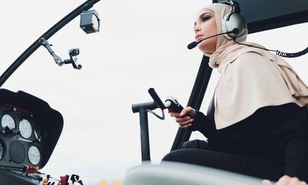 Elegant business muslim arab woman near the helicopter. Business, success and luxury concept.の写真素材