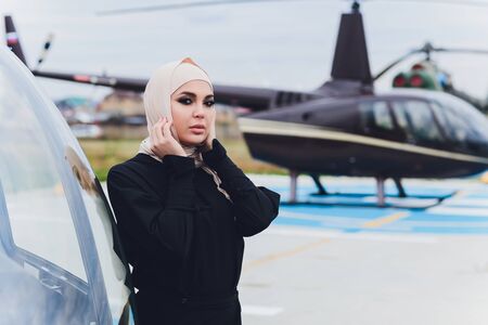 Elegant business muslim arab woman near the helicopter. Business, success and luxury concept.の写真素材