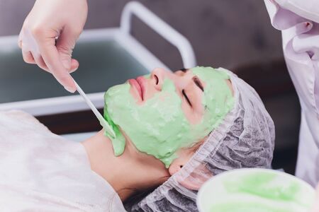 Upper view of a womansUpper view of a woman's face covered by alginate mask while leaning on a spa bedの写真素材