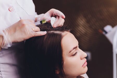 Needle mesotherapy. Cosmetic been injected in womans head. Thrust to strengthen hair and their growth.の写真素材