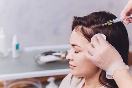 Needle mesotherapy. Cosmetic been injected in womans head. Thrust to strengthen hair and their growth.の写真素材
