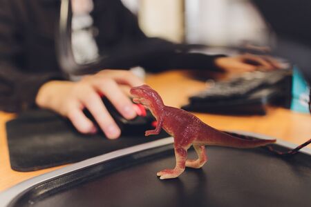 Shooting Tyrannosaurus T-rex Dinosaur against the background of a programmer at a computer.