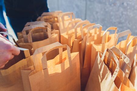 Close up brown clear empty blank craft paper bag for takeaway isolated on pastel pink background....