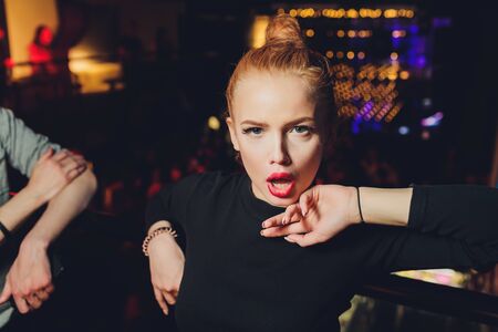 Attractive woman dressed in fashion apparel in neon night lights.