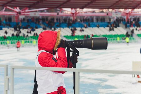 A sports photographer working at a soccer game.の写真素材