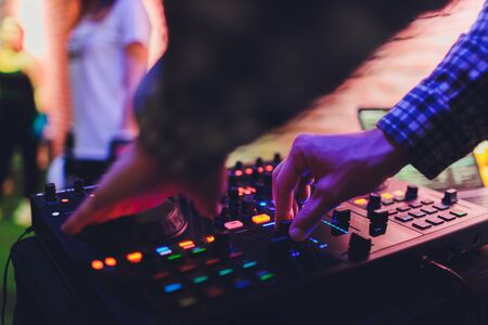 DJ remote, turntables, and hands . Night life at the club, party.