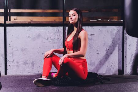 Athletic young woman doing some exercises with a rope outdoor.