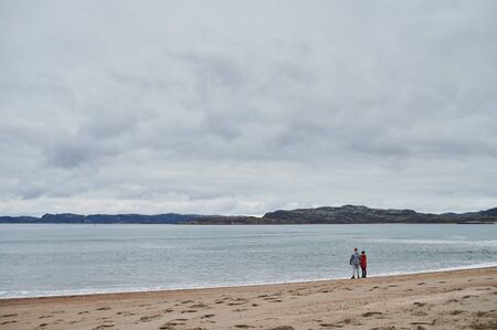 Beautiful summer day landscape abandoned artnature coastal defense North Teriberka, Barents sea view. couple admiring the view.の写真素材