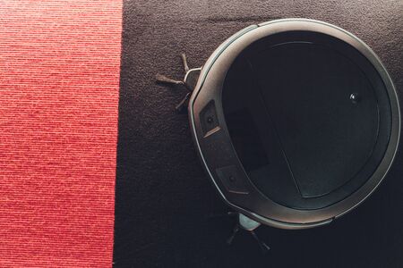 Robotic vacuum cleaner on carpet - technology housework.の写真素材