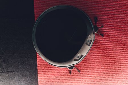 Robotic vacuum cleaner on carpet - technology houseworkの写真素材