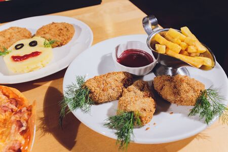 Child food. Funny food. Plate with cutlets and mashed potatoes in the form of a monkey faces. Children's menuの写真素材