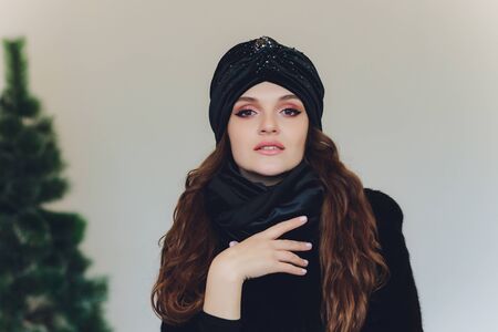 Surprised happy beautiful woman looking sideways in excitement. Christmas girl wearing knitted warm hat and mittens, isolated on gray background.の写真素材