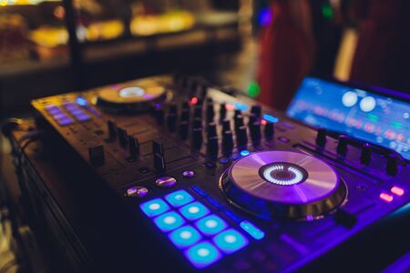 DJ remote, turntables, and hands . Night life at the club, party