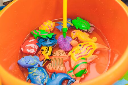 fishing in the paddling pool. Children's toys in the pool. Toy fish fishing rod. Cheerful children...