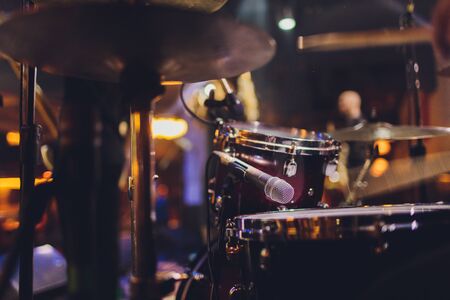 The man is playing drum set in low light backgroundの写真素材