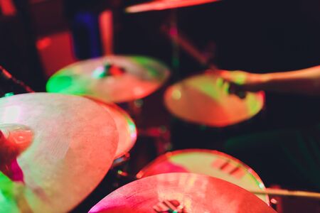 The man is playing drum set in low light background.の写真素材