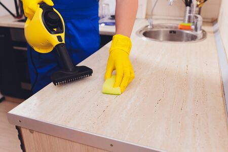man cleaning kitchen with steam cleaner spongeの写真素材