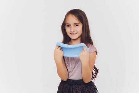 Young girl playing with slime. Isolated on white background.の写真素材