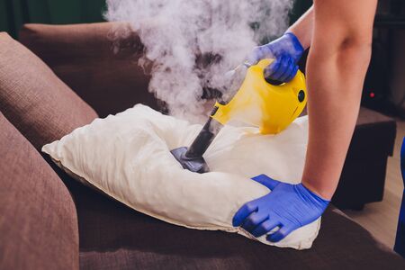 Using dry steam cleaner to sanitize pillow.の写真素材
