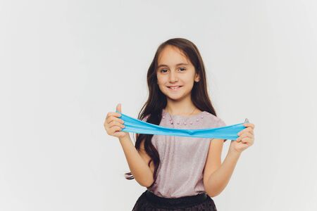 Young girl playing with slime. Isolated on white background.の写真素材