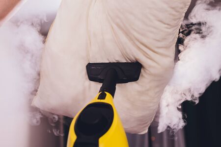 Using dry steam cleaner to sanitize pillowの写真素材