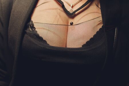 Decollete, female breast. Neckline black dress and fur collar.