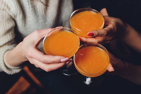 Close up shot of group of people clinking glasses with wine or champagne in front of bokeh background. older people hands.の写真素材