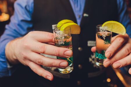 Hand holding a glass with vodka shotの写真素材