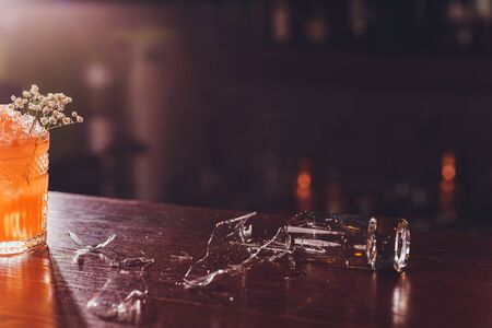 Broken wine glass on wooden bar counterの写真素材