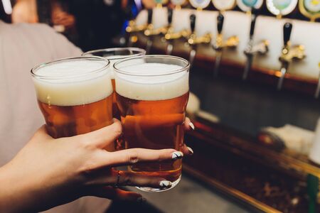 Woman holding three glasses of beer bartender.の写真素材
