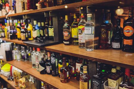 Ufa, Russia, 1 January, 2020: Several types of bottled alcohol are displayed on some shelves in a pub.のeditorial素材