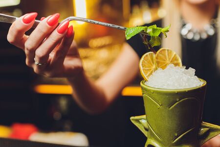 A bartender makes a cocktail over the marble bar counterの写真素材