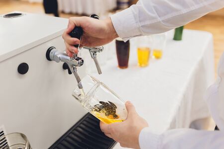 Bartender pouring draft beer in the barの写真素材