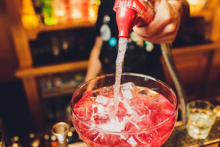 bartender prepares a great cocktail close-up on the background of the barの写真素材