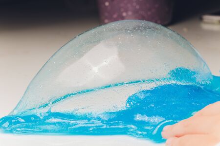 Kid Playing Hand Made Toy Called Slime Alien drool Shell mussel.の写真素材