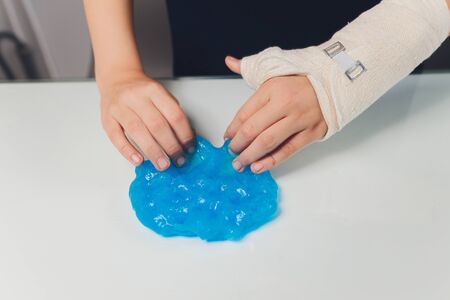 Kid Playing Hand Made Toy Called Slime Alien drool Shell mussel. childrens hand in a castの写真素材