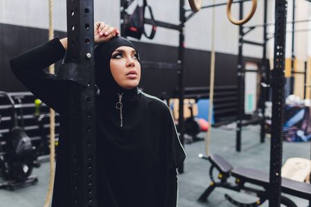 Muslim asian woman in hijab exercizing in a gym.の写真素材