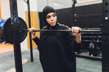 Muslim asian woman in hijab exercizing in a gym.の写真素材