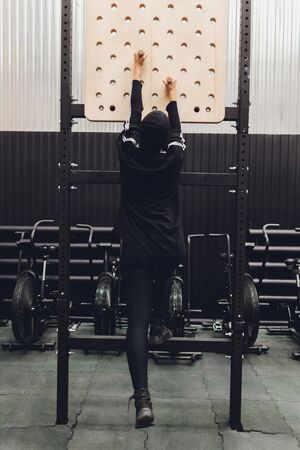 Muslim asian woman in hijab exercizing in a gym.