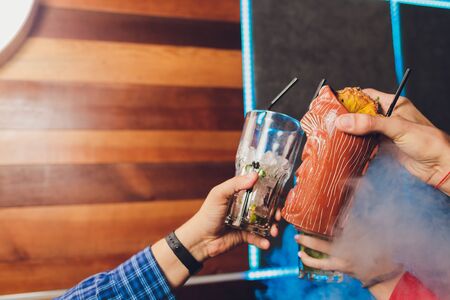 Bartender pouring strong alcoholic drink into small glasses on bar, shots.
