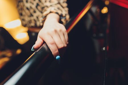 Woman hand using a railing to go upstairs with a light grey background.の写真素材
