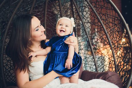 mom holds her lovely child tender standing in a room.の写真素材