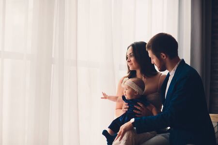 young beautiful happy family in elegant clothes with little smiling child.の写真素材