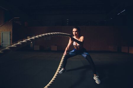 beautiful athletic woman working out with ropes box gym copyspace confidence motivation sports...