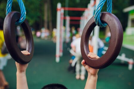 Children's hands and gymnastic rings man's hands