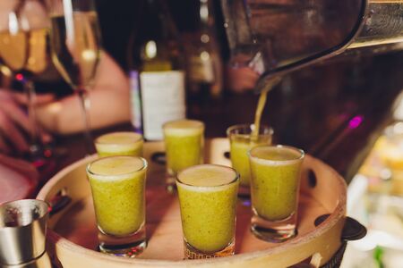 Cozy home holiday concept. Tasty alcoholic sweet drinks fruits juices beverages. Man takes a shot of...
